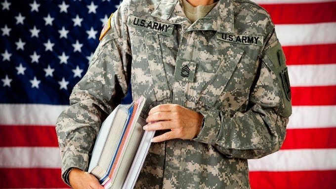 Solider in fatigues holding books under arm